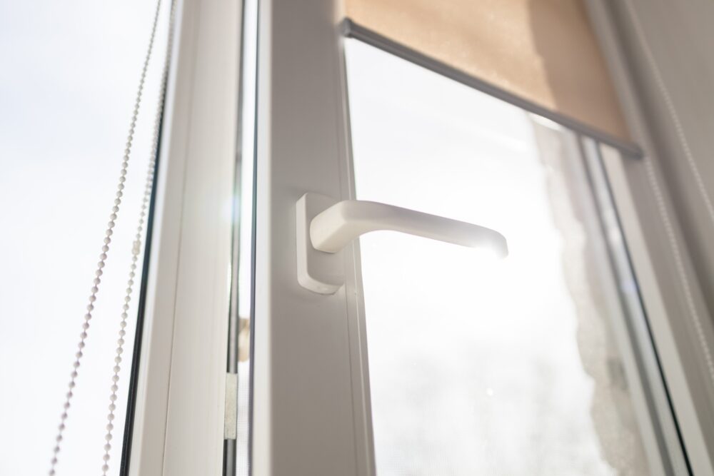 White plastic pvc window with forest background at home. Sunbeam through glass